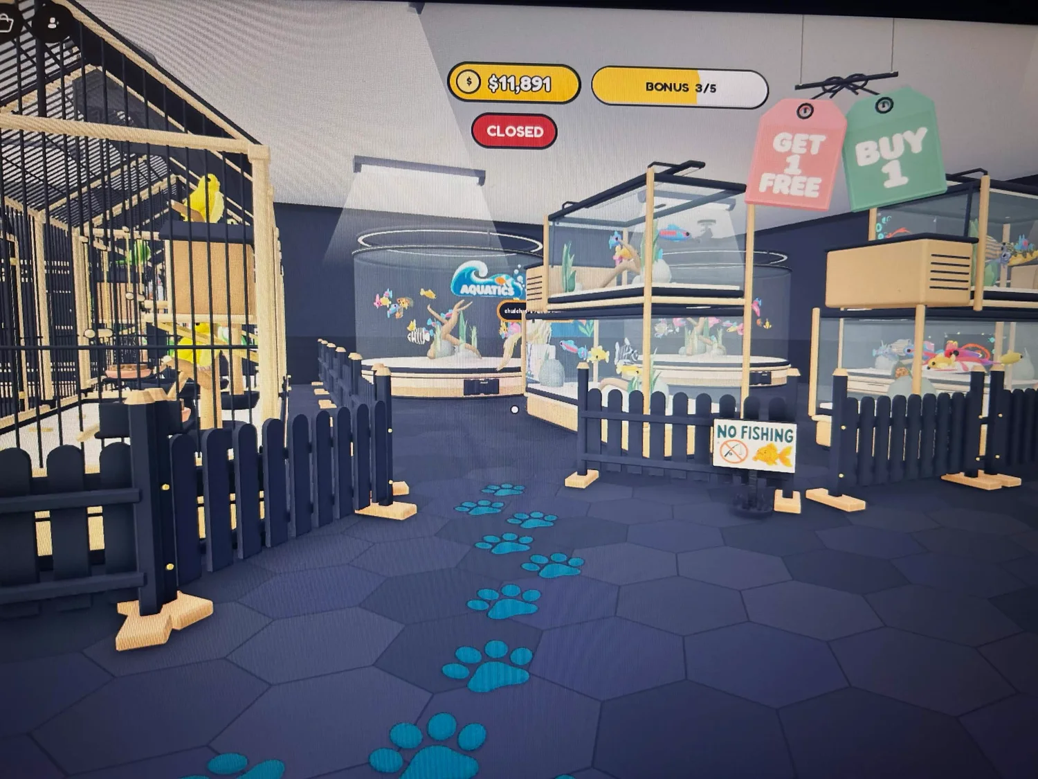 A teal paw-print trail leading between dark fences to round and rectangular fish tanks.