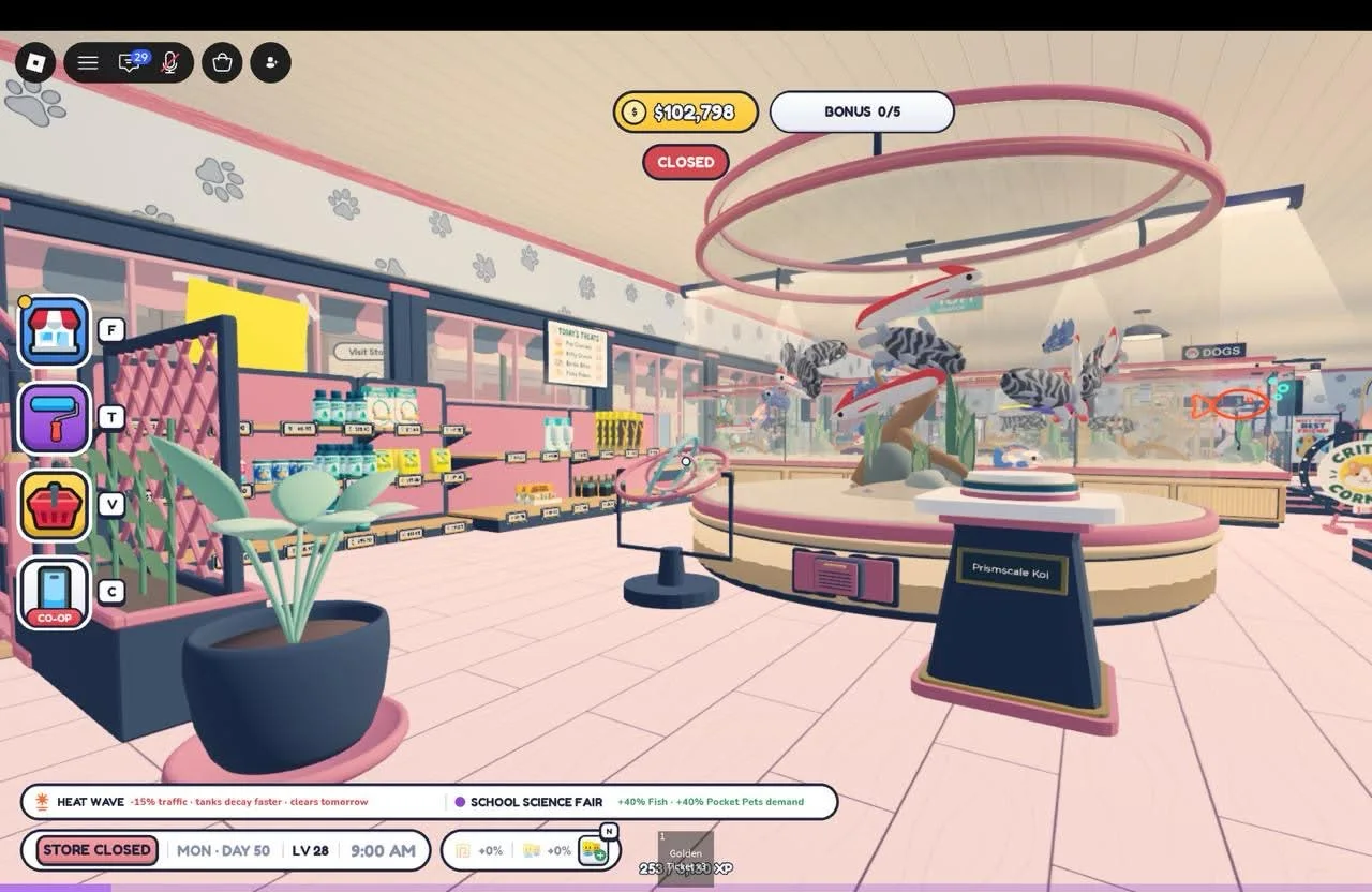 A round fish display beneath pink ring-shaped ceiling fixtures, with a planted entrance and stocked shelves nearby.