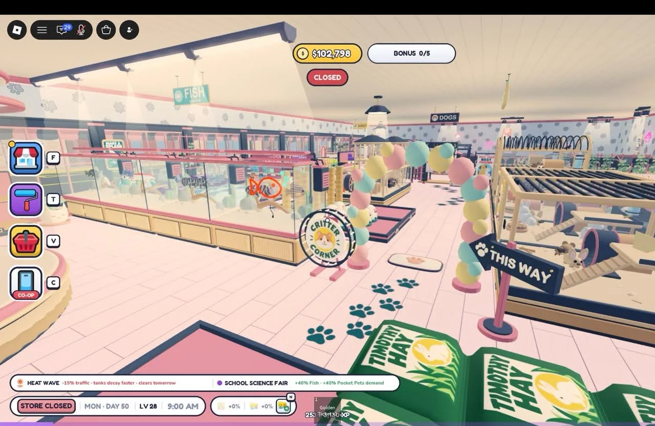 Aquarium and animal displays beside a pastel balloon arch, direction sign and paw-print aisle.